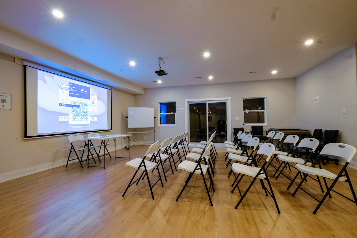Projector and large screen setup in the Green River villa at CozyCotts Stay, ideal for group presentations, seminars, and movie nights.